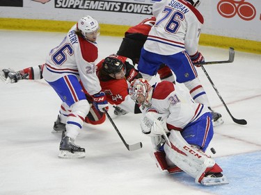 The puck goes past Montreal Canadiens' Carey Price (31) after a shot by Ottawa Senators' Jean-Gabriel Pageau (44), as Canadiens' P.K. Subban (76) and Jeff Petry (26) protect the crease during the second period of an NHL Stanley Cup playoff hockey game, Sunday April 26, 2015, in Ottawa. The shot, which entered the net, was deemed a no-goal.