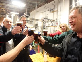 The Royal Oak is turning 35 and has asked Kichesippi Beer to make a British ale to celebrate. Royal Oak chief executive Jonathan Hatchell, left, and president John Howard toast the new brew with other employees at Kichesippi.