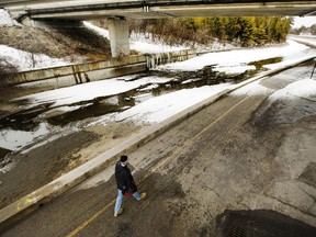 The scene where a 20-year-old cyclist suffered  life-threatening injuries after going over a knee-high wall on the Rideau Canal walkway, pictured, is photographed Thursday April 02, 2015. Ottawa Paramedics had to clamber down into the still-empty canal in response to an 8:15 p.m. Wednesday after a report of a man on bike tumbling off the path that runs along the waterway near the Heron Road Bridge. They found him lying in the canal suffering from a serious head injury.