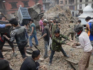 TOPSHOTS People clear rubble in Kathmandu's Durbar Square, a UNESCO World Heritage Site that was severely damaged by an earthquake on April 25, 2015. A massive 7.8 magnitude earthquake killed hundreds of people April 25 as it ripped through large parts of Nepal, toppling office blocks and towers in Kathmandu and triggering a deadly avalanche that hit Everest base camp.