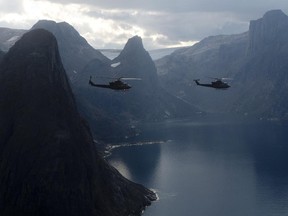 Two Canadian military Griffon helicopters fly along the shoreline of Baffin Island in 2014 .
