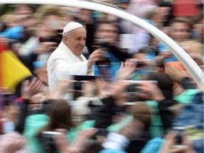 Pope Francis greets the crowd from the popemobile after the Easter Mass on April 5, 2015 in Vatican. Pope Francis condemned, yesterday, indifference and "complicit silence" to jihadist attacks on Christians as he presided over Easter ceremonies in the wake of a massacre of nearly 150 people at a Kenyan university by Shebab Islamists. The leader of the world's 1.2 billion Catholics brought up the extremist persecution of Christians as the holiest ceremonies of the Church calendar reached a climax today, when believers celebrate the resurrection of Jesus.