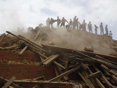 Volunteers help remove debris of a building that collapsed at Durbar Square, after an earthquake in Kathmandu, Nepal, Saturday, April 25, 2015. A strong magnitude-7.9 earthquake shook Nepal's capital and the densely populated Kathmandu Valley before noon Saturday, causing extensive damage with toppled walls and collapsed buildings, officials said.