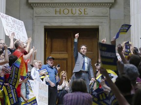 In this March 30, 2015 file photo, Rep. Warwick Sabin, D-Little Rock, cheers with others protesting over new religious objections laws at the state Capitol in Little Rock, Ark. The national focus on whether new religious objections laws in Indiana and Arkansas could be used to discriminate against gays and lesbians has boosted efforts for broader civil rights law protections in those and other states.