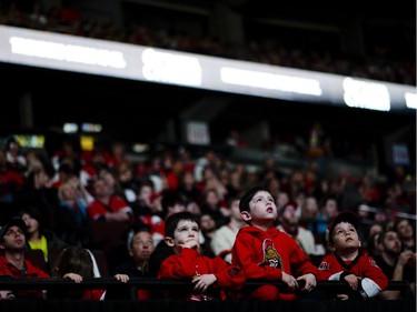 Young Ottawa Senators fans (L-R) Logan Dundas, Ellyott Dundas and Xavier Brochu watches the away game between the Senators and Flyers at Canadian Tire Centre on Saturday, April 11, 2015.