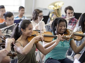 Rinila Haridas, 15, left, and Elizabeth Joseph, 14, right, are two violinists  from the Orkidstra program at the Bronson Centre. Rinila is heading to Sweden in June to perform in a prestigious concert.