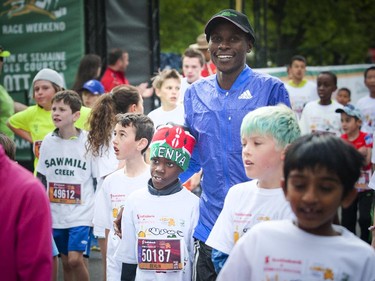 Devlin Taillon, 8, with Kenyan mentor David Kogei, who finished the 10K yesterday in third place at the end of the kids marathon at Tamarack Ottawa Race Weekend, Sunday, May 24, 2015.