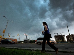 A person hurries to the bus shelter as storm clouds and severe weather threaten commuters and pedestrians along Merivale Road in 2014.