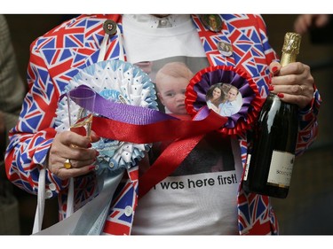 A wellwisher holds champagne to celebrate the birth of the royal baby, outside the Lindo Wing, St. Mary's Hospital, London, Saturday, May 2, 2015. Kate, the Duchess of Cambridge, has given birth to a baby girl, royal officials said Saturday.