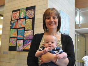 Jillian O'Connor and son Declan in front of painting Legacy in lobby of the critical care wing of The Ottawa Hospital General Campus.