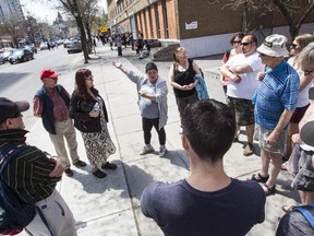 Alison Hoffman, centre with arms outstretched, describes her experiences with homelessness to a group of about 20 people who went on a Jane's Walk tour Sunday of areas of significance to the homeless. To Hoffman's immediate right, walk host and community activist Jane Scharf looks on. (Bruce Deachman, Ottawa Citizen)