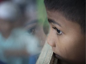 Sadhussin Mohamad, 6, a Rohingya schoolboy, watches teacher day celebrations outside his classroom at a Rohingya Education Center in Klang, Malaysia on Thursday, May 21, 2015. With more work opportunities than Indonesia and a more Muslim-friendly environment than Thailand, Malaysia has long been the destination of choice for Rohingya Muslims fleeing persecution in Burma.