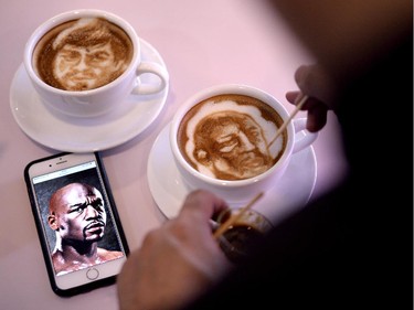 Graphic artist and barista Zach Yonzon uses coffee latte milk froth to illustrate depictions of Philippine boxing icon Manny Pacquiao (R) and US American boxer Floyd Mayweather at his cafe in Manila on April 23, 2015. Pacquiao's face is on shirts, dolls and postage stamps, his life story is playing in movie houses and millions are getting ready to party as the Philippine boxing hero's "fight of the century" nears.