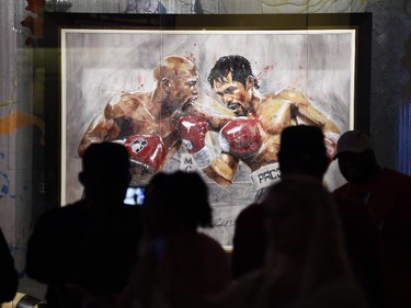 People view a painting of Floyd Mayweather and Manny Pacquaio called "The Superfight" by artist, Richard Slone, at an art gallery in the MGM Grand Hotel, May 1, 2015.  Mayweather and Pacquiao will meet in the ring on May 2, 2015 at the MGM Grand Garden Arena.