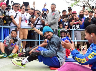 A crowd gathers to watch as boxer Manny Pacquiao, together with suporters and training mates, work out  at a park following his morning jog in Los Angeles on April 21, 2015. The Filipino congressman and world champion boxer will fight Floyd Mayweather in Las Vegas, Nevada, on May 2 in what is being billed as the "Fight of the Century" between the first and only eight-division world champion Pacquiao and undefeated five-division world champion Mayweather.