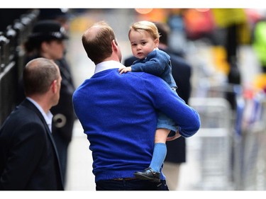 Britain's Prince William, Duke of Cambridge (L), picks up his son Prince George of Cambridge after he refused to walk from a car as they return to the Lindo Wing at St Mary's Hospital in central London, on May 2, 2015 where his wife Catherine, Duchess of Cambridge, gave birth to their second child, a baby girl, earlier in the day. The Duchess of Cambridge was safely delivered of a daughter weighing 8lbs 3oz, Kensington Palace announced. The newly-born Princess of Cambridge is fourth in line to the British throne.