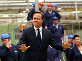 Britain's Prime Minister David Cameron talks to staff during a visit to a tea factory in Stockton-on-Tees, England, Tuesday May 12, 2015, his first engagement outside London since winning the general election.