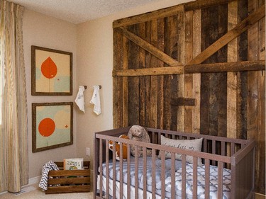 One of the secondary bedrooms in the Vail 2 is a conversation starter. Decorated as a nursery, the wall behind the crib features a barn-style door done in reclaimed wood.