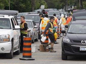 Cars line up to drop off waste at a hazardous waste drop-off at Tunney's Pasture in Ottawa on Sunday, May 31, 2015.