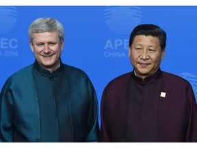 Canada's Prime Minister Stephen Harper (L) poses with Chinese President Xi Jinping upon arrival for Asia-Pacific Economic Cooperation (APEC) Summit banquet at the Beijing National Aquatics Center in the Chinese capital on November 10, 2014. Top leaders and ministers of the 21-member APEC grouping are meeting in Beijing from November 7 to 11.