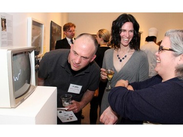 Conceptual sound artist Donna Legault, centre, discuses her work with Jen Valiquette while fellow artist Robert Hinchley takes a closer look during the Ottawa Art Gallery's Le pARTy art auction fundraiser, held on Thursday, May 21, 2015.
