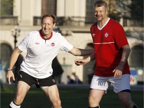Conservative MP Peter Mackay, left, puts a hand on the National Post's John Ivison as parliamentarians and members of the press gallery play a friendly soccer match on the front lawn of Parliament Hill in celebration of 2015, the Year of Sport in Canada, and to promote the upcoming FIFA Women's World Cup 2015 in Canada Wednesday.