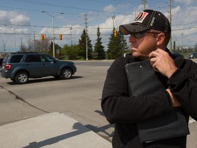 Constable Phil Kane scans the street for distracted drivers while officers down the road wait to write tickets on May 12, 2015. Kane said that in about an hour the trap caught 20 separate drivers. The Ottawa Police set up multiple traps for distracted drivers across the city. Photo Taken at 11:07.  (Micah Bond / Ottawa Citizen)