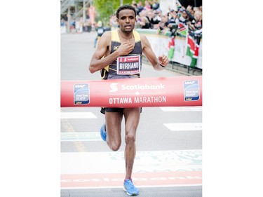 Ethiopia's Girmay Birhanu hits the finish line of the marathon at Tamarack Ottawa Race Weekend, Sunday, May 24, 2015.
