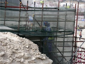 In this May 4, 2015, file photo taken during a government organized media tour, a foreign worker climbs scaffolding at the Al-Wakra Stadium that is under construction for the 2022 World Cup in Doha, Qatar. Amnesty International said Thursday, May 21, that Qatar is failing to deliver on reforms for its low-paid migrant workers a year after the wealthy Gulf nation announced plans to improve conditions for laborers building its highways, hotels, stadiums and skyscrapers.