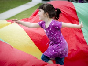 Five year old Chloe Myers plays in a parachute at the annual Sheep Shearing Festival at the Canadian Agricultural and Food Museum Saturday May 16, 2015.