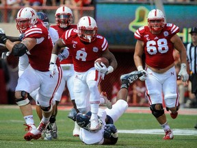 LINCOLN, NE - AUGUST 30: Offensive lineman Jake Cotton (68) follows running back Ameer Abdullah #8 of the Nebraska Cornhuskers up the field as slips by linebacker Robert Relf #43 of the Florida Atlantic Owls during their game at Memorial Stadium on August 30, 2014 in Lincoln, Nebraska. Nebraska defeated Florida Atlantic 55-7.