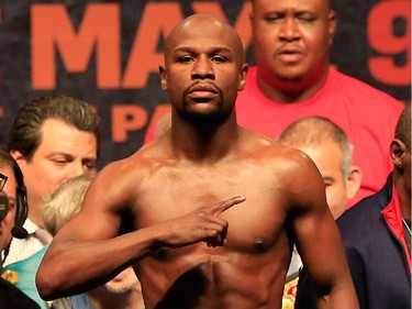 Floyd Mayweather Jr. poses on the scale during his official weigh-in on May 1, 2015 at MGM Grand Garden Arena in Las Vegas, Nevada. Mayweather will face Manny Pacquiao in a welterweight unification bout on May 2, 2015 in Las Vegas.