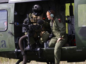 An air crewman with the Canadian Armed Forces shows another solider the weapons system on a CH-146 Griffon Helicopter during Exercise Maple Resolve 2015 at the Canadian Manoeuvre Training Center, Camp Wainwright, Alberta, May 5, 2015. The Marines and Sailors of 1st Air Naval Gunfire Liaison Company, I Marine Expeditionary Force Headquarters Group, teamed up with members of the Canadian Armed Forces and conducted a series of close air support missions from fixed and rotary wing aircraft using live munitions. (U.S. Marine Corps photo by Staff Sgt. Bobbie Curtis)