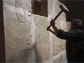 This image made from video posted on a militant social media account affiliated with ISIL appears to show a militant taking a sledgehammer to an Assyrian relief at the site of the ancient Assyrian city of Nimrud.