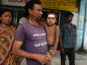 An Indian child is held by his father after receiving treatment at Siliguri Hospital in Siliguri on May 12, 2015, after falling during an earthquake. A new earthquake of 7.3-magnitude and several powerful aftershocks hit devastated Nepal on May 12, killing at least four people and sending terrified residents running into the streets of the traumatized capital. The quake was felt as far away as New Delhi.