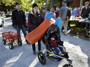 James Thompson's slide had the first ride, with parents Laura and Jordan, amidst the hundreds of people who flocked to the Glebe for the neighbourhood's famous annual garage sale, which was as big as ever, attracting second-hand deal hunters from all over the city, on Saturday morning, May 23, 2015.