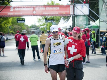 Jean-Mar Theriault gets a little help after finishing the marathon at Tamarack Ottawa Race Weekend, Sunday, May 24, 2015.