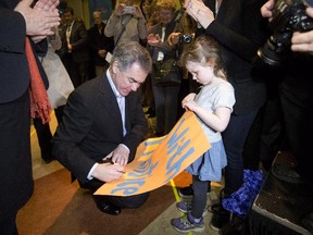 Then Alberta Premier Jim Prentice signs a sign for a young supporter after announcing a spring election in Edmonton, on Tuesday, April 7, 2015.