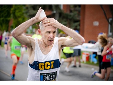 John Rainford uses some water to cool down during the 5K run at Tamarack Ottawa Race Weekend Saturday May 23, 2015.