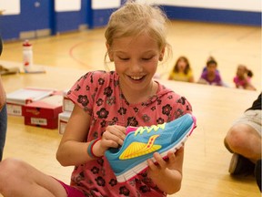 Kim Carnite admires her new shoes at Robert E. Wilson Public School on May 19, 2015. A large number of children were surprised with free shoes as part of the Start2Finish program.