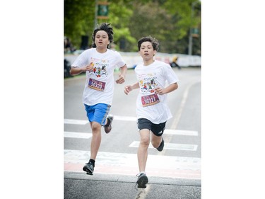 L-R: John Clermont and Owen McKinley-Young push to the finish line of the kids marathon at Tamarack Ottawa Race Weekend, Sunday, May 24, 2015.