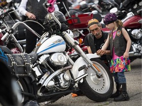 Lilly Ashford, 5, and her father Maurice Landriault with his motorcycle at the 15th Ottawa Telus Motorcycle Ride for Dad at Aviation Museum on Saturday, May 30, 2015.