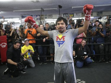 Manny Pacquiao, of the Philippines, raises his arms after his workout in front of reporters and photographers Wednesday, April 15, 2015, in Los Angeles. Pacquiao is scheduled to fight Floyd Mayweather Jr. in a welterweight boxing match in Las Vegas on May 2.