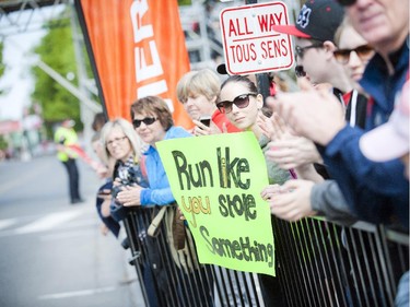 Melina Alain from Montreal holds a sign, "Run like you stole something," as she cheers on friends running the marathon at Tamarack Ottawa Race Weekend, Sunday, May 24, 2015.