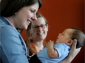 Midwife Elyse Banham (left) checks out new mom, Sarah Posthuma, and her four-week-old baby, Benjamin Posthuma-Lee, at the Midwifery Group of Ottawa's offices on Carling Avenue.