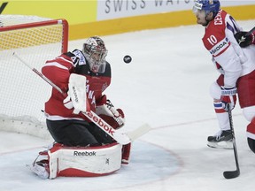 Canada's goalkeeper Mike Smith blocks a shot as Czech Republic's Roman Cervenka, right, looks on during the Hockey World Championships semifinal match in Prague, Czech Republic, Saturday, May 16, 2015.