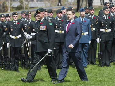 Minister Pierre Poilievre inspects the guards at a ceremony in Ottawa, May 3, 2015.