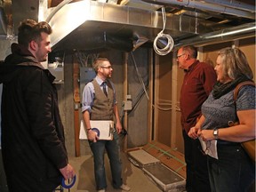 Nicholas Ramsay, service manager for Claridge Homes, second left, takes home buyer Matthew King, left, and his parents, Greg and Kelly King, through the inspection of his townhome in Summerhill.