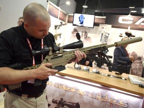 Patrice Picard shows off a CADEX sniper rifle at the Canadian Association of Defence and Security Industries' CANSEC trade show in Ottawa this week.