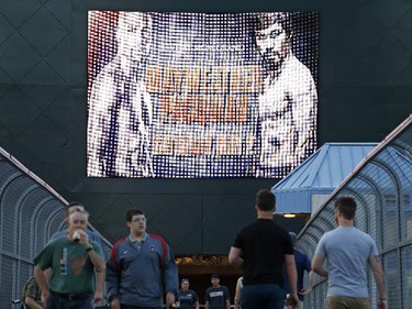 People walk across a footbridge by a sign advertising the boxing bout between Floyd Mayweather Jr. and Manny Pacquiao, Wednesday, April 22, 2015, in Las Vegas.